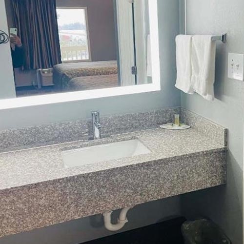 Pink granite bathroom vanity top with backspashes and front apron for Travelodge motel
